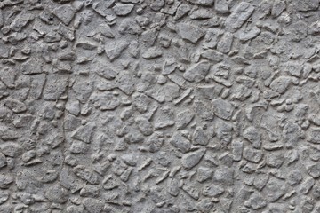 Gray surface of the concrete wall with a pronounced relief. Closeup.