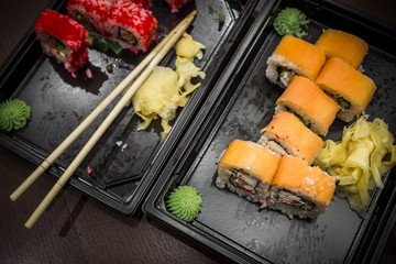 Almost eaten Japanese rolls packed in plastic containers for the delivery of fast food