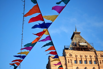 Moscow, Russia - December 16, 2018: Decorative multicoloured flags of the GUM fair against the blue sky