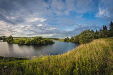 landscape of the riverbank at sunset with the sun above the horizon