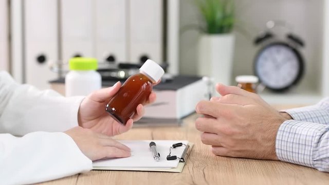 Doctor recommends generic cough syrup to a patient in medical office