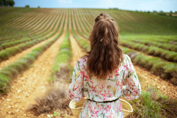 young woman standing at green field in Provence, France