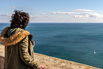 Unidentifiable woman looking at the ocean.