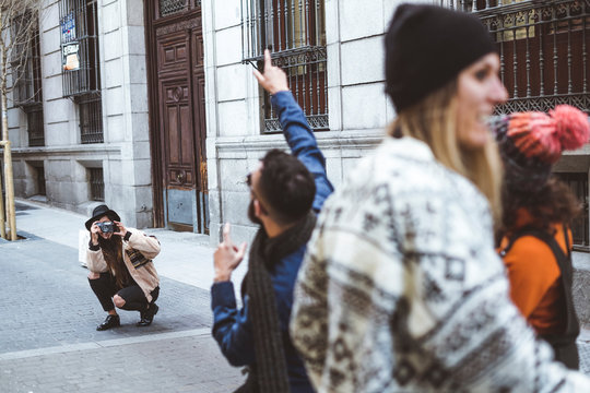 group of friends they're taking pictures on the street