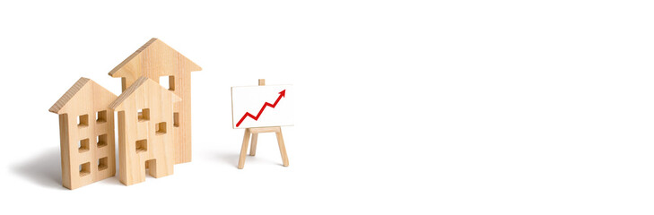 Wooden houses stand with red arrow up. Growing demand for housing and real estate. The growth of...