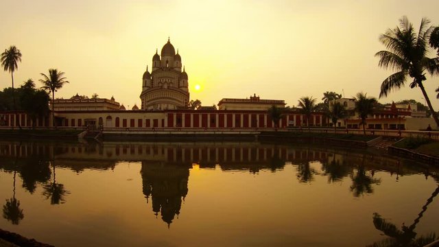 Ramakrishna mission sun droops near Kali temple reflection in pond colorful sunset palms Kolkata