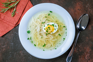Chicken soup bouillon in a plate with egg