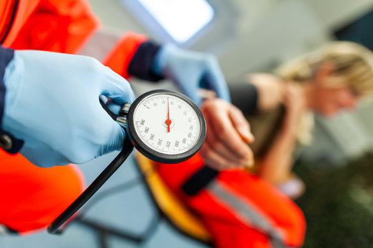 German paramedic checks the blood pressure of a patient