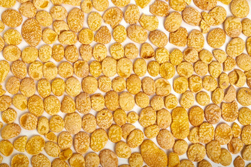 Abstract corn flakes background or banner. Corn flakes food wallpaper. Gold corn flakes. Minimal flat lay. Abstract texture pattern background. 