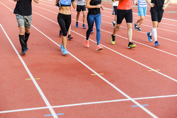 Group at the stadium running outdoors training.
