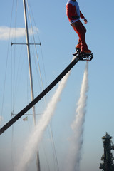 Vertical View of Santa Claus on Flyboard on Blue Sky Background. Taranto, Italy
