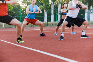 Cropped image of sport group at the stadium make exercises