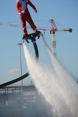 Vertical View of Santa Claus on Flyboard on Blue Sky Background. Taranto, Italy