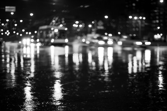 Rainy city road at night. Defocused black and white image