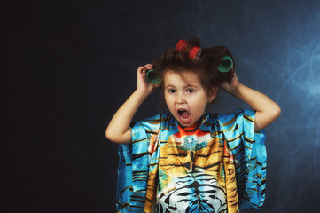 Portrait of a little fashionable girl in curlers .The concept of femininity