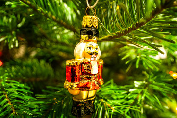 Small nutcracker bauble on Christmas tree. Xmas decoration.
