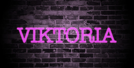 Fototapeta premium first name Viktoria in pink neon on brick wall