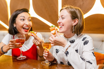 Two female friends Drink wine and enjoy meal at the restaurant