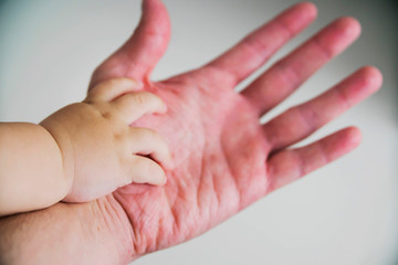 the child's hand in the parent's hand