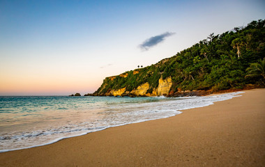 Fototapeta na wymiar Tropical sunset at the beach with palms