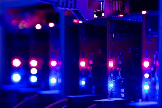 Equipment For Mining Crypto Bitcoin Token, Etherium Cash Close-up. Electronic Boards And Chips, Blue And Red Lights. Blurred Server Lights