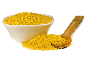 millet in white ceramic bowl isolated on white. Spilled millet. Yellow millet groats in ceramic bowl, isolated on white background