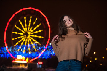 Young girl posing in a amusement park on a winter night.