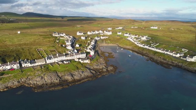 Stunning Aerial Drone Shot in Scottish Highlands, high to low reveal of Portnahaven on the Isle of Islay