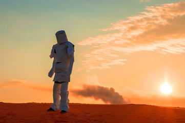 man in the wilderness in a torn spacesuit, goes after the crash of the rocket, amid smoke.