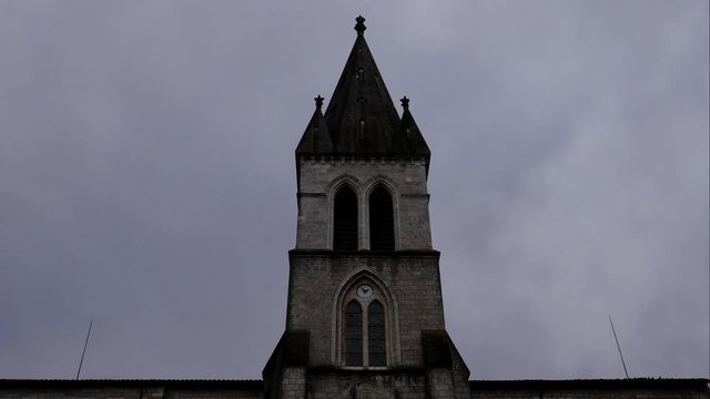 Timelapse of the peak of a small cathedral in a french village, 4K