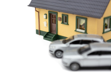 Silberne Modellautos vor Modellhaus