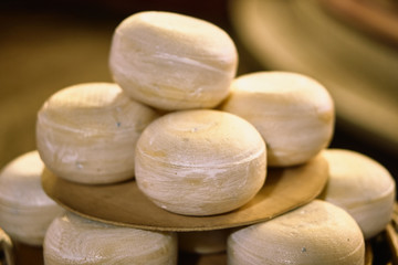 Multiple cheeses on a plate and basket outside on a christmas market
