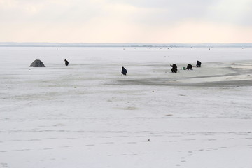 Russia. Fishermen catch fish from ice holes in the ice. Winter fishing/Россия. Рыбаки ловят рыбу из проруби во льду. Зимняя рыбалка.