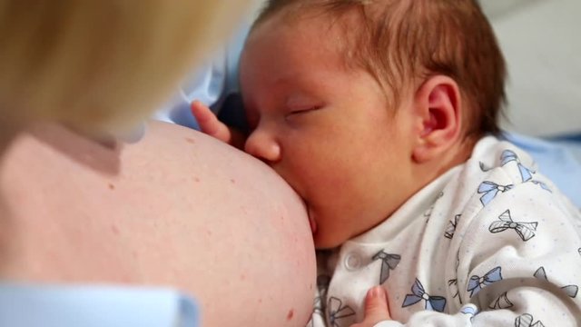Mother breastfeeds the baby, close up.
