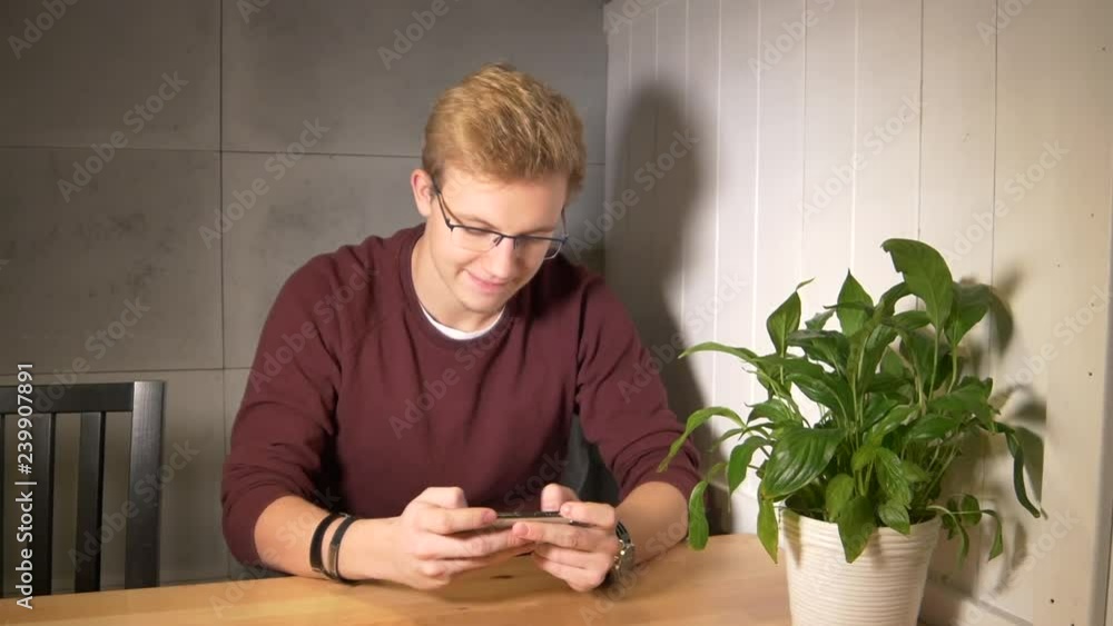 Aufkleber man intensely playing the mobile game. using smartphone horizontally. winning the game