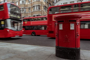 Rucksack roter Briefkasten in London mit vorbeifahrendem Doppeldeckerbus © NDStock