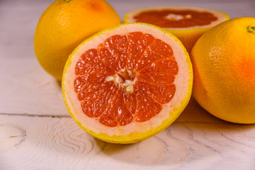 Ripe juicy grapefruit on a white wooden table