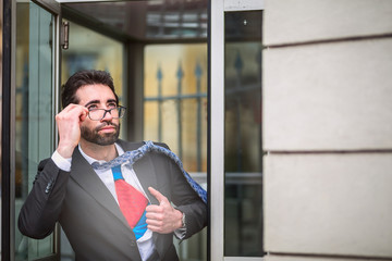 Young businessman acting like a super hero and tearing his shirt