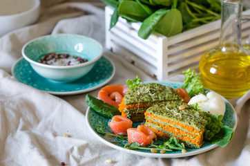 Healthy breakfast or lunch. Carrot-spinach cake with red fish, poached egg, pine nuts, lettuce and micro green.