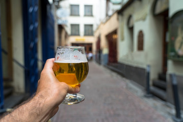 Hand holding glass of beer