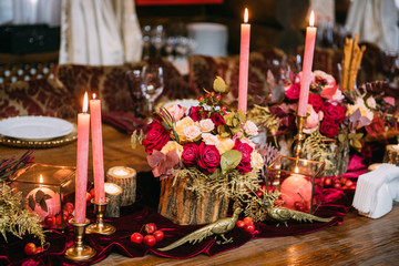 Wooden table decorated with flowers and candles