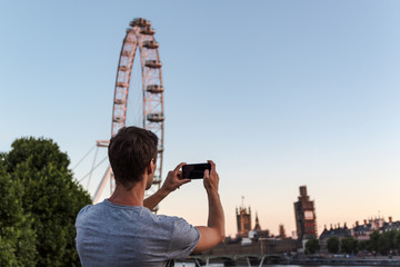 One young man taking a picture of the big ben during renovation