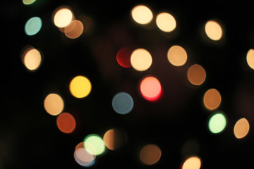 Blurred defocused christmas light lights bokeh background. Colorful red yellow blue green de focused glittering pattern concept.