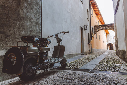old grey scooter parked in a narrow alley in Ascona