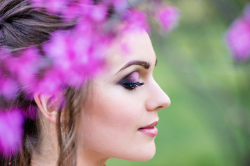 Naklejka premium Portrait of a beautiful girl in flowers. Professional makeup. Fashion model in work. Wedding make-up. Portrait of a stylish bride.
