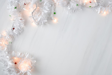 White holiday christmas lights strand around a blank white backdrop