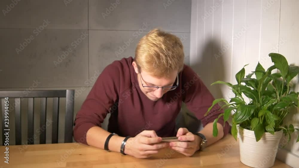 Aufkleber man intensely playing the mobile game. using smartphone horizontally. winning the game