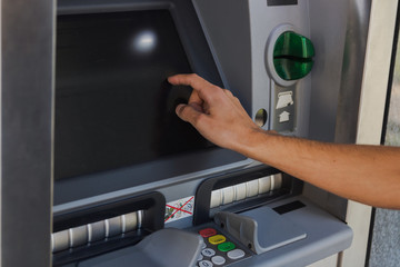 young man withdrawing cash from a cash machine