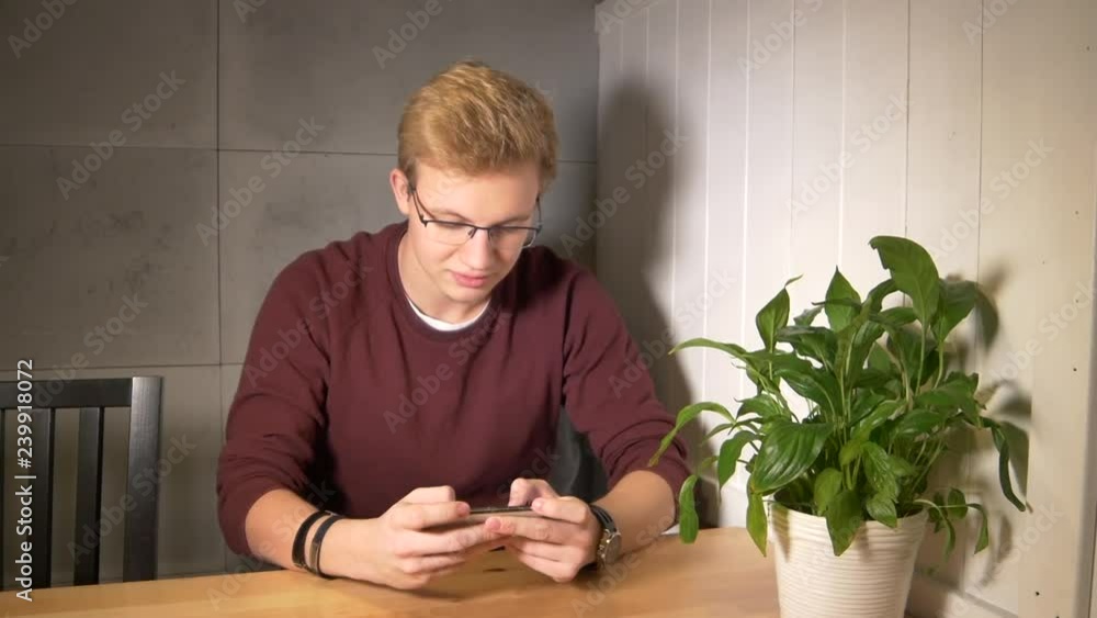 Aufkleber man intensely playing the mobile game. using smartphone horizontally. winning the game