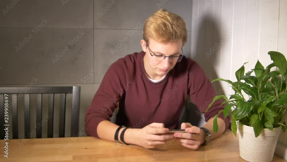 Aufkleber man intensely playing the mobile game. using smartphone horizontally.